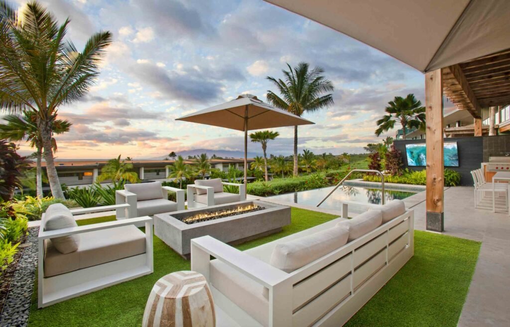 Luxury hotel patio with modern outdoor furniture malaysia style, featuring white sofas, fire pit, pool, and tropical landscape.