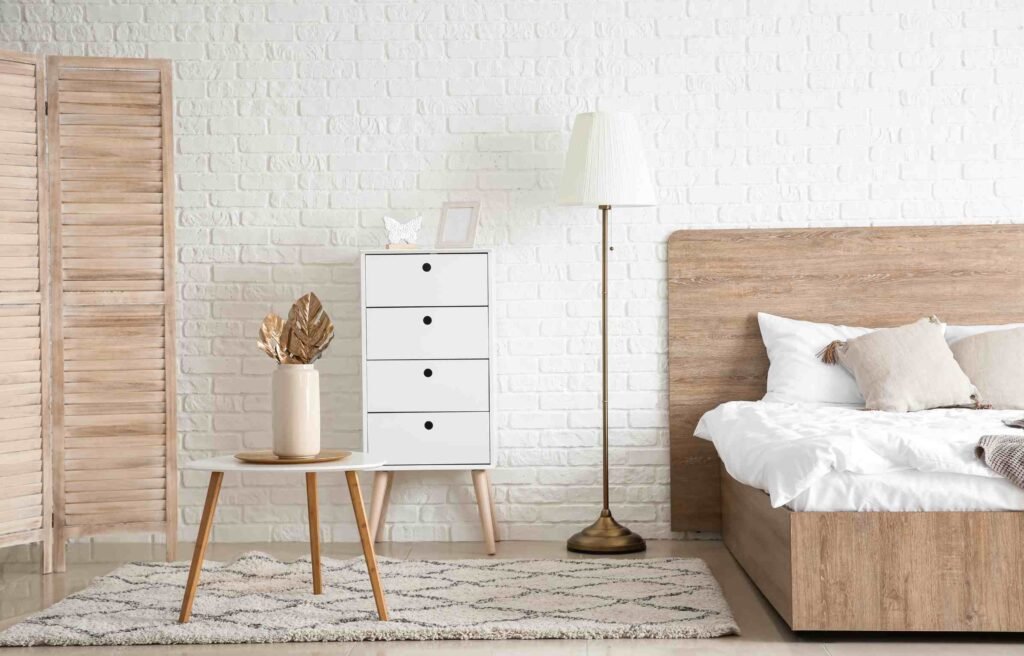 Modern bedroom with a wooden bed, white chest of drawers, and soft lighting, showcasing elegant bedroom furniture in malaysia.